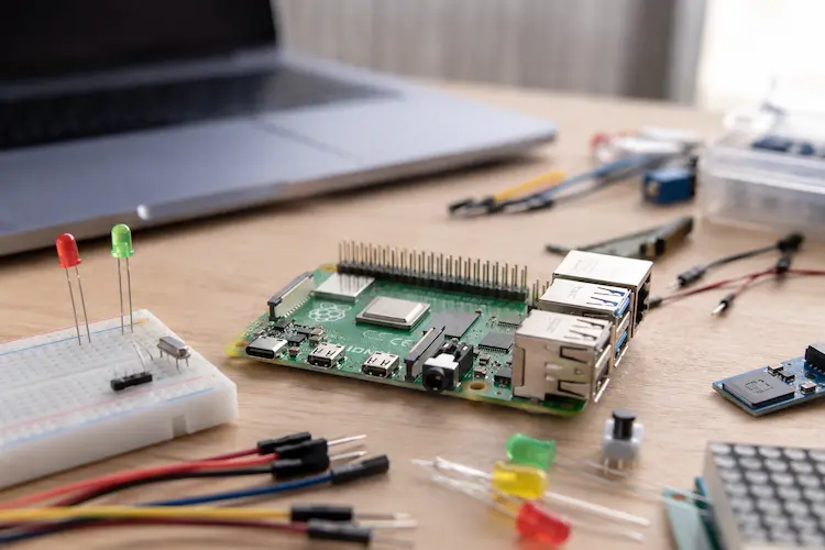 placa Raspberry Pi em uma bancada maker com protoboard, LEDs e cabos para projeto iniciante.
